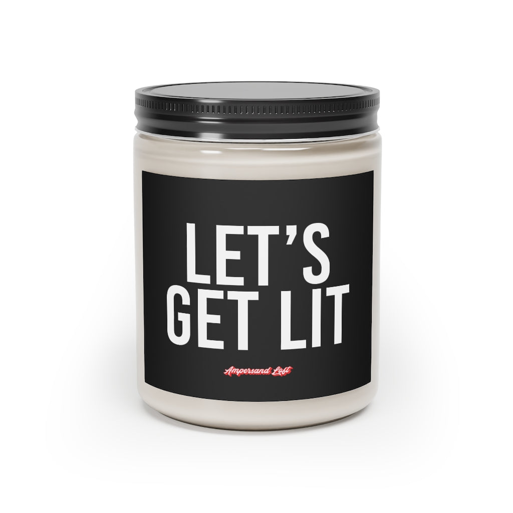 Candle in a glass jar with black label that reads, in white All-Caps text "Let's Get Lit." and a small "Ampersand Loft logo below (pink retro font with solid red drop shadow)