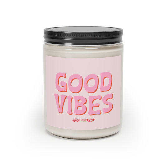 Candle in a glass jar with light pink label that reads, in a pink All-Caps, groovy text, with red drop shadow "Good Vibes." and a small "Ampersand Loft logo below (pink retro font with solid red drop shadow)